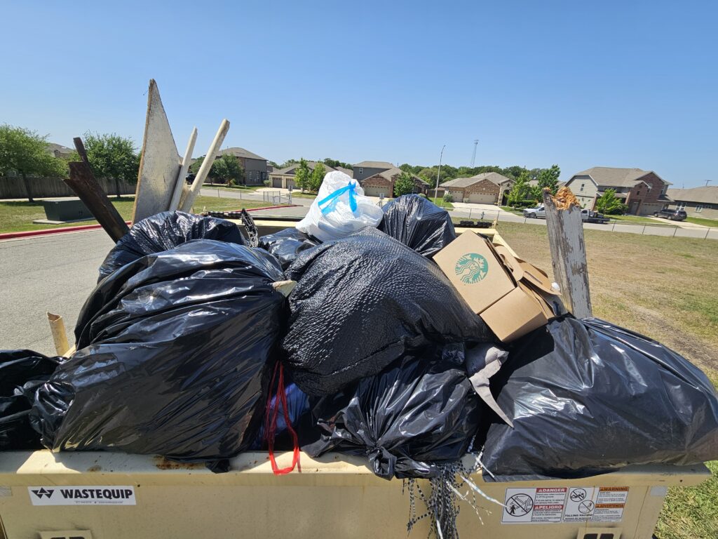 Bags of trash in a dumpster